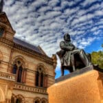 Mitchell Building and a seated bronze statue at the University of Adelaide’s North Terrace campus.