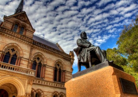 Mitchell Building and a seated bronze statue at the University of Adelaide’s North Terrace campus.