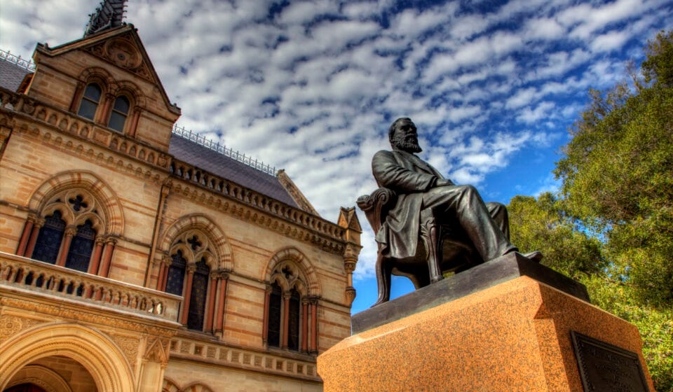 Mitchell Building and a seated bronze statue at the University of Adelaide’s North Terrace campus.